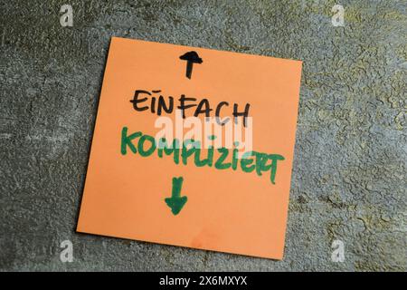 Concept of Learning language - German. Einfach Kompliziert it means Simply complicated written on sticky notes. German language isolated on Wooden Tab Stock Photo