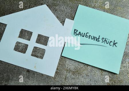 Concept of Learning language - German. Baugrundstuck it means Building ground written on sticky notes. German language isolated on Wooden Table. Stock Photo