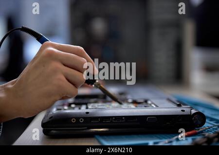 Hand technician repairing broken laptop notebook computer with tools, alone, at workshop. Unrecognizable professional specialist repairing computer. C Stock Photo