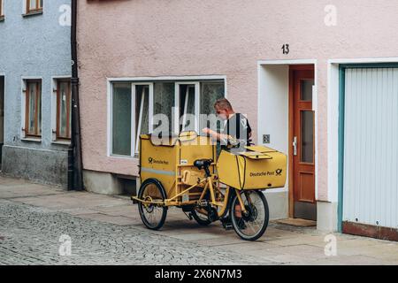 Fussen, Germany - August 14, 2023: The postman delivers mail on the streets of Füssen Stock Photo