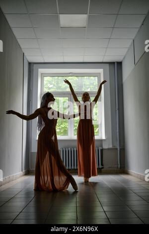 Silhouette of two female dancers rehearsing choreography in the hallway of theatre Stock Photo