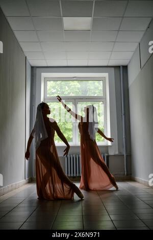 Silhouette of two ballerinas repeat dance steps in the corridor Stock Photo