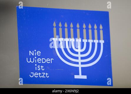 PRODUCTION - 22 March 2024, Hesse, Frankfurt/Main: A sticker with the words 'Never again is now' and the Hanukkah candelabrum is emblazoned on a door of the Bockenheim depot as a sign against anti-Semitism, hatred and hate speech. The conflict in the Middle East is also having an impact on Hesse: The Ministry of the Interior is registering an increase in anti-Semitic crimes. Photo: Arne Dedert/dpa Stock Photo