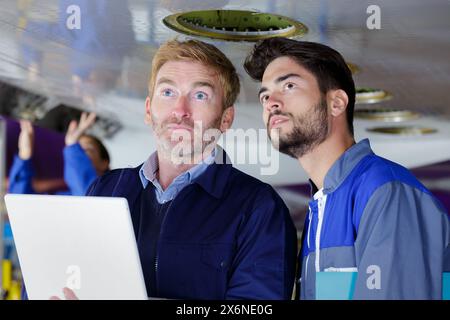 aero engineer and apprentice working in hangar Stock Photo