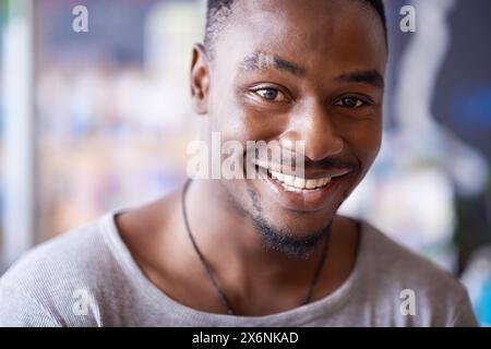 Smile, portrait and black man at cafe to relax, cheerful and positive face for leisure at restaurant in Kenya. Facial, cafeteria and happy African Stock Photo