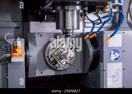 Modern 5 Axis CNC advance metal Milling Machine working in heavy industry factory. Drilling machine on working process in workshop Stock Photo