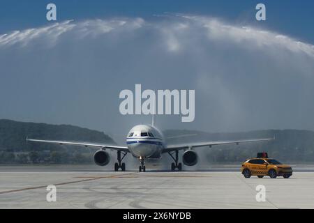 HANGZHOU, CHINA - MAY 16, 2024 - Flight CA726 from Osaka, Japan, passes through the 'water gate' set up at Hangzhou Xiaoshan International Airport to Stock Photo