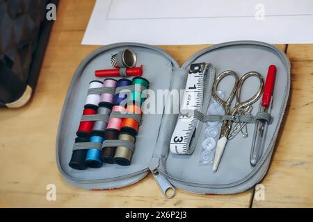 Sewing kit including colored thread, scissors, measuring tape, pins and needles Stock Photo