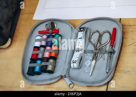Sewing kit including colored thread, scissors, measuring tape, pins and needles Stock Photo