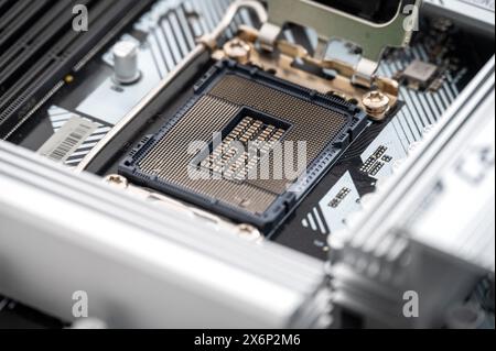 Detailed close-up view of an empty CPU socket on a sleek, modern motherboard. The image showcases intricate technology components used in advanced com Stock Photo