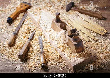 old tools: wooden planer, hammer, chisel  in a carpentry workshop on wooden table Stock Photo