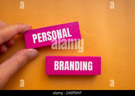 Personal branding words written on wooden pink blocks with orange background. Conceptual personal branding symbol. Copy space. Stock Photo
