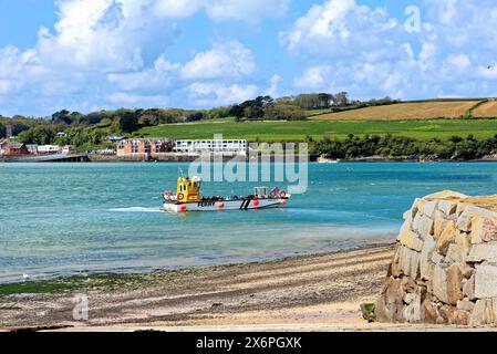 The view across the River Camel estuary from Rock with the passenger ferry arriving from Padstow on a sunny spring day, North Cornwall England UK Stock Photo