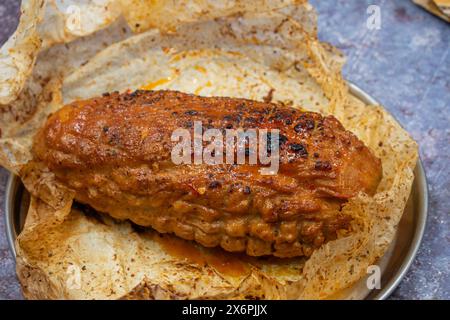 Home made washed flour seitan ham, cooked and roasted. Sliced and served on white plate along asparagus Stock Photo