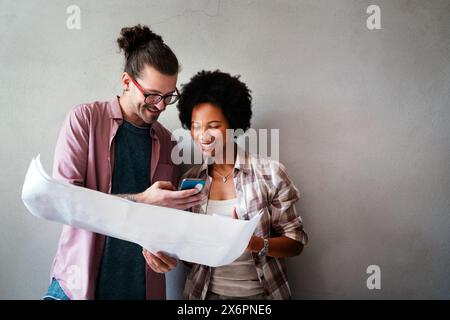 Diverse group of happy employees analyzing reports with digital device, working together in office Stock Photo