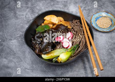 Vegan wood ear mushrooms stir fried with bok choy, radish daikon, buckwheat noodles Stock Photo