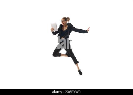 Happy businesswoman in formal wear jumping and emotionally looking on tablet isolated on white background. Project and budgeting approval Stock Photo