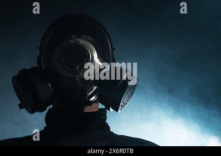 Caucasian man in a gas mask standing in front of smoke. Stock Photo