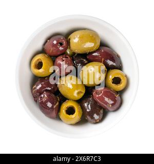 Pitted Kalamata and green olives, in a white bowl. Mix of organic green and black Greek olives with herbs, preserved in native olive oil. Stock Photo