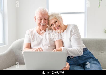 elder couple using online app, banking service on laptop, making payment, order, booking apartment Stock Photo