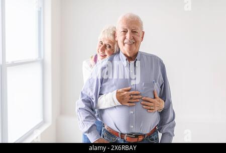 senior retired couple having great moment together close to a window Stock Photo