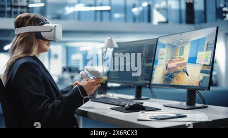 Industrial Software Developer Writing Code and Testing 3D Interior Design Interface. Engineer Editing and Moving Furniture while Wearing Virtual Reality Headset and Using Controllers. Stock Photo