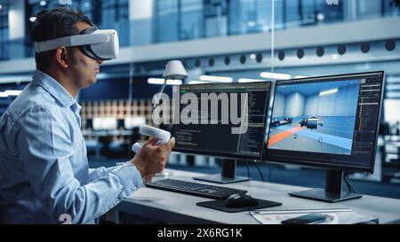 Industrial Software Developer Writing Code and Testing Automotive Manufacturing Interface. Engineer Editing Electric Motor and Car Chassis while Wearing Virtual Reality Headset and Using Controllers. Stock Photo