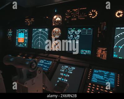 Cockpit view of an airplane during a night-time flight with illuminated instrument panels Stock Photo