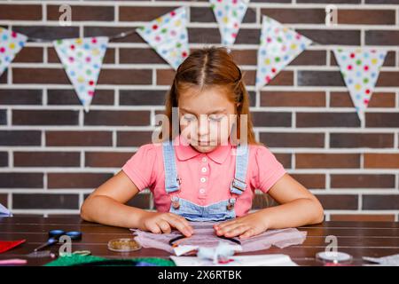 Cute preschooler girl makes art at a summer outdoor party Stock Photo