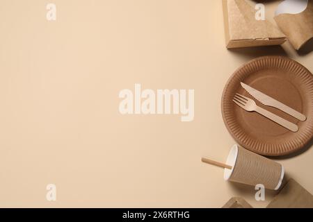Eco friendly food packaging. Paper containers and tableware on beige background, flat lay. Space for text Stock Photo