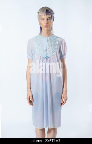 A Waist-up portrait of a young woman wearing a floral embroidered dress and a silver leaf headband. Stylish and modern look, fashion and beauty indust Stock Photo