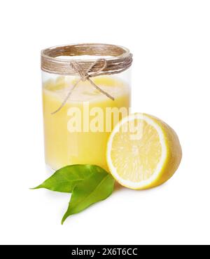 Delicious lemon curd in glass jar, fresh citrus fruit and green leaves isolated on white Stock Photo