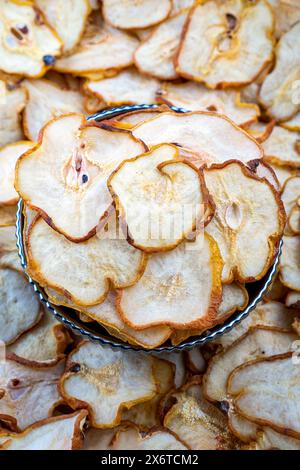 Sliced Dried Pears in a Decorative Bowl, Healthy Snack, Close-up of thinly sliced dried pears artistically arranged in a decorative metal bowl. Stock Photo
