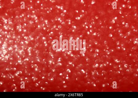 Shiny red background with glare and blurred bokeh . Festive glitter gradient. Christmas, New Year, Birthday, March 8, Valentine's and International Wo Stock Photo