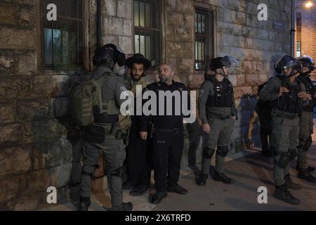 JERUSALEM - MAY 14: Members of the Israeli security forces detain a member of Neturei Karta, a fringe ultra-Orthodox Jewish movement within the anti-Zionist bloc during a rally against the creation of the state of Israel in the religious neighborhood of Mea Shearim as Israel celebrates 76th Independence Day, amid continuing battles between Israel and the militant group Hamas in Gaza strip on May 14, 2024 in Jerusalem. Neturei Karta opposes Zionism and calls for a 'peaceful dismantling' of the State of Israel, in the belief that Jews are forbidden to have their own state until the coming of the Stock Photo