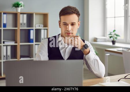 Thoughtful Businessman Engaged in Office Work with Laptop Stock Photo
