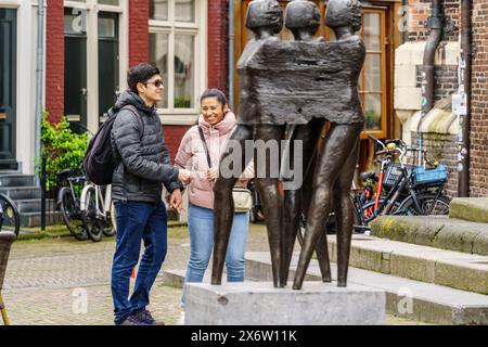 couple in front of the sculpture of Monument Jordaanoproer van Sofie Hupkens, Noordermarkt street market, Amsterdam, Netherlands. Stock Photo