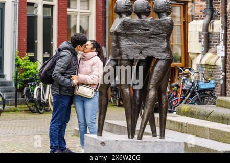 couple in front of the sculpture of Monument Jordaanoproer van Sofie Hupkens, Noordermarkt street market, Amsterdam, Netherlands. Stock Photo