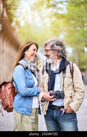 Loving elderly tourist couple looking at romantic outdoors in city. Smiling adult people traveling. Stock Photo