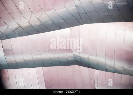 A building with a silver roof has a pattern of squares. The roof is curved and the squares are arranged in a way that creates a sense of movement. The Stock Photo