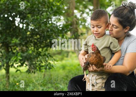 latina mother showing her son a chicken, boy afraid of chicken Stock Photo