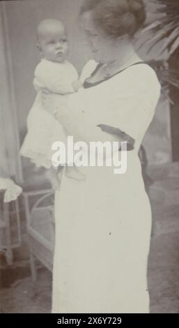 Four and a half month old baby Klaas Kleiterp in the arms of his mother Tine Kleiterp-Vermeulen in Malang, Part of Photo album of the Kleiterp-Vermeulen family with recordings of the children Klaas and Tiny in the Dutch East Indies., photograph, Klaas Kleiterp (I), (attributed to), Malang, 1920, paper, height, 107 mm × width, 62 mm Stock Photo