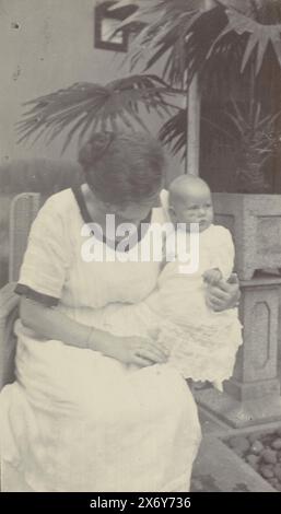 Four and a half month old baby Klaas Kleiterp in the arms of his mother Tine Kleiterp-Vermeulen in Malang, Part of Photo album of the Kleiterp-Vermeulen family with recordings of the children Klaas and Tiny in the Dutch East Indies., photograph, Klaas Kleiterp (I), (attributed to), Malang, 1920, paper, height, 107 mm × width, 62 mm Stock Photo