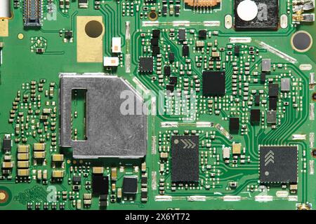 a green printed circuit board full of soldered components Stock Photo