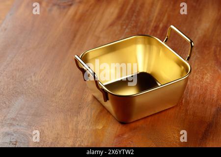 An empty aluminium container on a wooden table Stock Photo