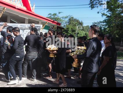 Phatthalung, Thailand- April 05, 2024: Man in black is helping to carry the coffin of the deceased into the crematorium for cremation Stock Photo