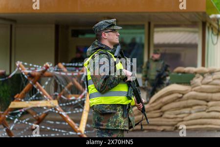 03 May 2024, Rhineland-Palatinate, Kirchheimbolanden: A Bundeswehr soldier secures access to an ammunition depot during an exercise. The Rhineland-Palatinate State Command is conducting an exercise with the Rhineland-Palatinate and Hunsrück homeland security companies to protect vital defense infrastructure on the site of the former ammunition depot near 'Kriegsfeld' (Donnersberg district). During the Bundeswehr exercise National Guardian, part of the Bundeswehr exercise series QUADRIGA, homeland security forces throughout Germany practise their core mission of protecting and securing vital de Stock Photo