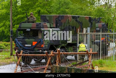 03 May 2024, Rhineland-Palatinate, Kirchheimbolanden: An ammunition transporter drives through the secured access to the ammunition depot during an exercise. The Rhineland-Palatinate State Command is conducting an exercise with the Rhineland-Palatinate and Hunsrück Homeland Security Companies to protect vital defense infrastructure on the site of the former ammunition depot near 'Kriegsfeld' (Donnersberg district). During the Bundeswehr exercise National Guardian, part of the Bundeswehr exercise series QUADRIGA, homeland security forces throughout Germany practise their core mission of protect Stock Photo