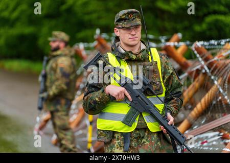 03 May 2024, Rhineland-Palatinate, Kirchheimbolanden: Bundeswehr soldiers secure access to an ammunition depot during an exercise. The Rhineland-Palatinate State Command is conducting an exercise with the Rhineland-Palatinate and Hunsrück homeland security companies to protect vital defense infrastructure on the site of the former ammunition depot near 'Kriegsfeld' (Donnersberg district). During the Bundeswehr exercise National Guardian, part of the Bundeswehr exercise series QUADRIGA, homeland security forces throughout Germany practise their core mission of protecting and securing vital defe Stock Photo