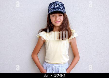 Lovely eleven year old girl wearing a baseball cap Stock Photo